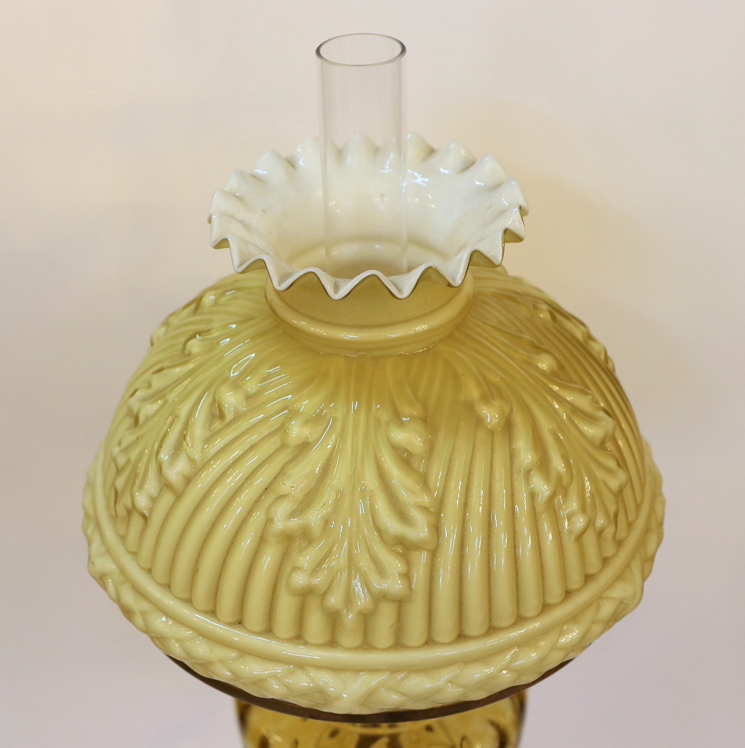 An Edwardian brass oil lamp with Toeb Elmann mechanism, yellow glass reservoir and opaque glass shade, height overall 70cm